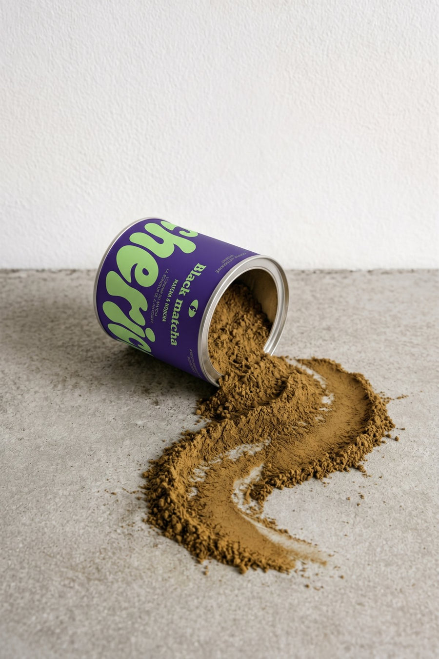 Pot Black Matcha renversé, la poudre répandue sur une surface en béton