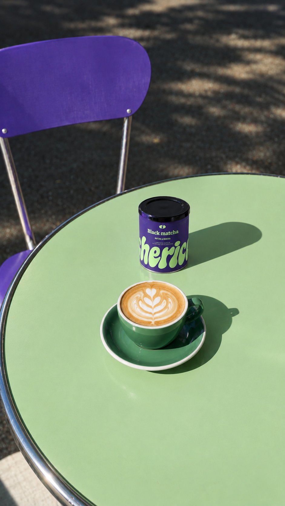 Latte Black Matcha dans une tasse verte, à côté du pot, sur une table de terrasse verte